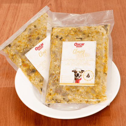 Two packages of Oscar Daisy dog food on a white plate with a wooden background