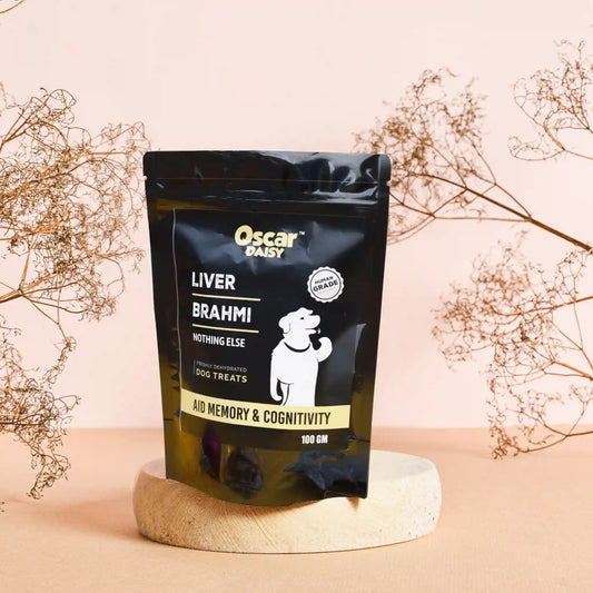Oscar Daisy dog treat package on a wooden stand with decorative branches in the background